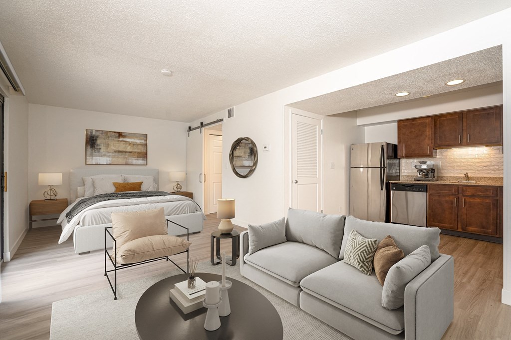 a living room with a couch and a coffee table and a bedroom with a bed